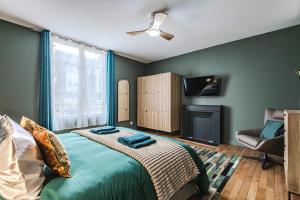 a bedroom with a bed with a television and a fireplace at La Maison Opaline in Reims