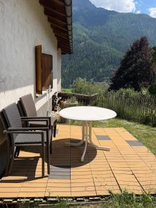a table and two chairs on a deck with a view at Chasa Patgific Studio in Ramosch