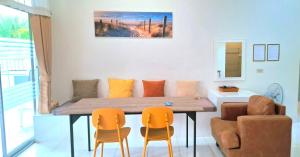a dining room with a wooden table and chairs at Pranburi Private Pool Villa Baan Prae by Baan Chaylay in Pran Buri