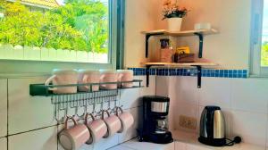 a kitchen with pink utensils on a wall at Pranburi Private Pool Villa Baan Prae by Baan Chaylay in Pran Buri