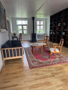 a living room with a couch and a table and chairs at Skelby Præstegård lej 1 in Gedser