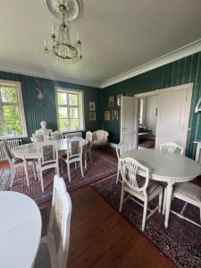 a dining room with tables and chairs and a chandelier at Skelby Præstegård lej 1 in Gedser