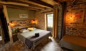 a bedroom with a bed and a brick wall at Chez Walter et Camille in Saint-Cernin-de-Larche