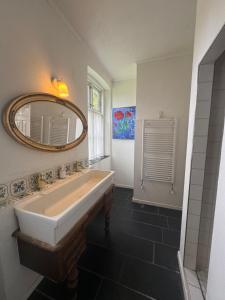 a bathroom with a sink and a mirror at Skelby Præstegård lej 1 in Gedser +39 photos