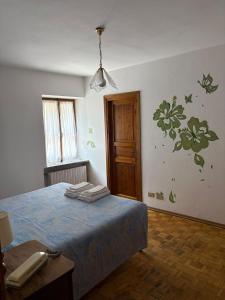 a bedroom with a bed with green flowers on the wall at Albergo Nonaj in Monticello d'Alba