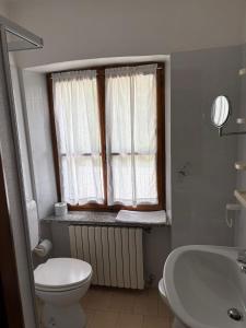 a bathroom with a toilet and a sink and a window at Albergo Nonaj in Monticello d'Alba
