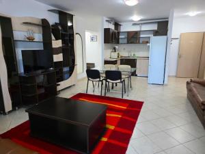 a living room with a black table and a kitchen at Club Onix Apartments in Neptun