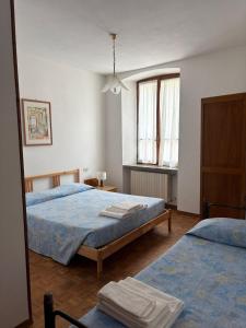 a bedroom with two beds and a window at Albergo Nonaj in Monticello d'Alba +9 photos