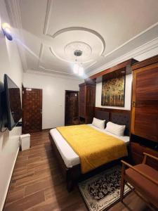 a bedroom with a large bed with a yellow blanket at Hotel Résidence Awa Plazza 2 in Dakar