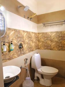 a bathroom with a toilet and a sink at V-Suites in Bangalore