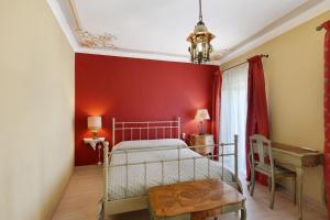 a bedroom with a bed and a red wall at Pietra Viva in Poggio