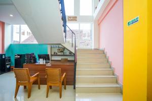 a staircase in a building with two chairs and a counter at SANS Stay Arkana Seturan Pakuwon Mall in Yogyakarta
