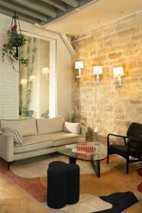 a living room with a couch and a table at Hôtel Marais Hôme in Paris