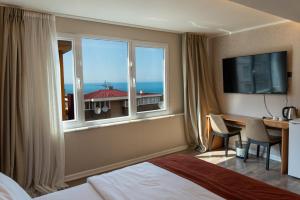 a hotel room with a bed and a desk and a window at The MU City Hotel Trabzon in Trabzon