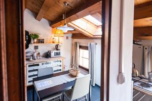 eine Küche und ein Esszimmer mit Tisch und Stühlen in der Unterkunft Torre Cà Emo, La Mansarda dell'Ammiraglio in Vittorio Veneto
