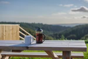 a coffee maker and a cup on a wooden table at Rivendell Farm Glamping in Carmarthen