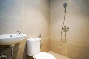 a bathroom with a shower and a toilet and a sink at SANS Stay Arkana Seturan Pakuwon Mall in Yogyakarta +42 photos