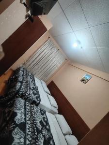 a bedroom with a bed with a black and white comforter at Hostal el barranco in Cuenca