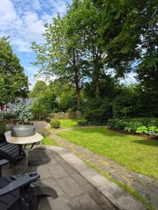 a patio with a table and a bench and a garden at Ferienwohnung Greitemann in Eslohe