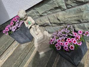 a statue and flowers on the side of a building at Ferienwohnung Greitemann in Eslohe +47 photos