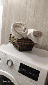 a basket of towels sitting on top of a washing machine at Vila Nela in Shkodër +58 photos
