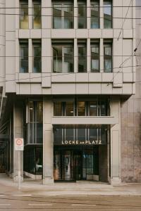 a large building with a sign in front of it at Locke am Platz Zurich in Zurich