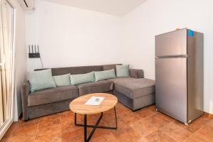 a living room with a couch and a table and a refrigerator at Apartment Veslo in Begovići