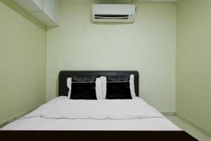 a bedroom with a white bed with a black headboard at Collection O Near Taiping Mall Formerly Axis Hotel in Taiping +41 photos