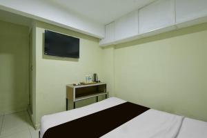a small room with a bed and a tv at Collection O Near Taiping Mall Formerly Axis Hotel in Taiping
