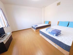 a room with two beds and a television in it at Guest House Asahi in Otaru +34 photos