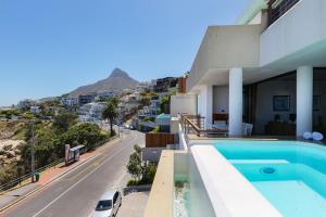 a house with a swimming pool next to a street at Bali Luxury Suite C in Cape Town