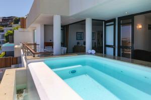 a swimming pool in front of a house at Bali Luxury Suite C in Cape Town