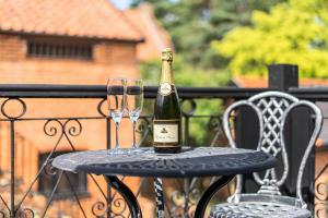 a bottle of champagne and two glasses on a table at Barn Conversion Sleeps 2 with Parking in Diss +16 photos