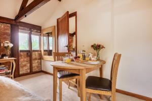 a dining room with a wooden table and chairs at Barn Conversion Sleeps 2 with Parking in Diss