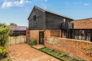 a brick house with a black roof at Barn Conversion Sleeps 2 with Parking in Diss