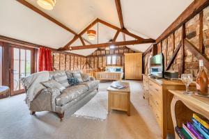 a living room with a couch and a tv at Barn Conversion Sleeps 2 with Parking in Diss