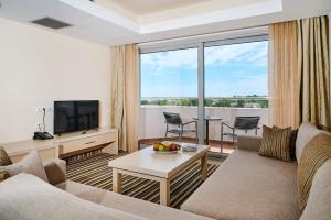 ein Wohnzimmer mit Sofa und Fernseher in der Unterkunft Cronwell Platamon Resort All-Inclusive in Platamonas