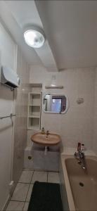 a small bathroom with a sink and a tub at Appartement plein centre-ville in Lodève +14 photos