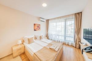 a bedroom with a bed and a large window at Premier Fort Beach Hotel in Sveti Vlas +131 photos