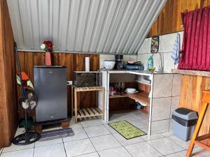 a kitchen with a sink and a microwave in a room at Cabaña Escondida Rio Celeste in El pilon +8 photos