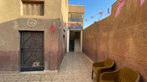 a door to a building with two chairs in a alley at Sunset Mirage House in Giza