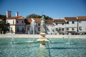 a fountain with a statue in the middle of the water at Casa dos Tios- Estremoz in Estremoz