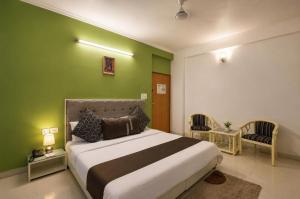 a bedroom with a large bed with a green wall at Hotel Silver Leaf, Noida in Noida +18 photos