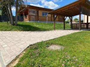 a pavilion in front of a house with a grass field at Blockhaus Nikolaus in Güssing +3 photos