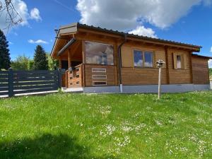 a house with a fence and a green field at Blockhaus Nikolaus in Güssing