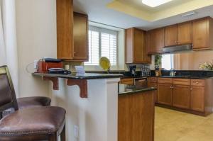 a kitchen with wooden cabinets and a counter top at Three Bedroom Corner Condo with Gulf View Balcony in Pensacola
