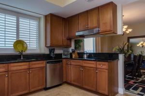 a kitchen with wooden cabinets and stainless steel appliances at Three Bedroom Corner Condo with Gulf View Balcony in Pensacola +19 photos