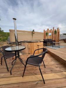 a patio with a table and chairs on a wooden deck at Le dôme de Clem in Figeac