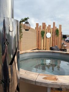 a hot tub in a backyard with a wooden fence at Le dôme de Clem in Figeac