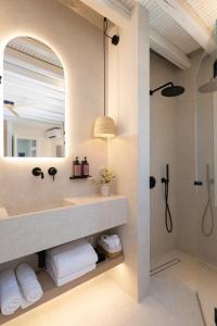 a bathroom with a shower and a mirror at Archipelago Sifnos - Seaside Accommodation in Vathi +93 photos